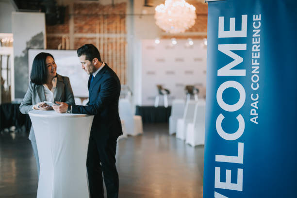istock Asian Chinese businesswoman final check going through programme details with banquet hall manager before the business conference seminar begin 1580739835
