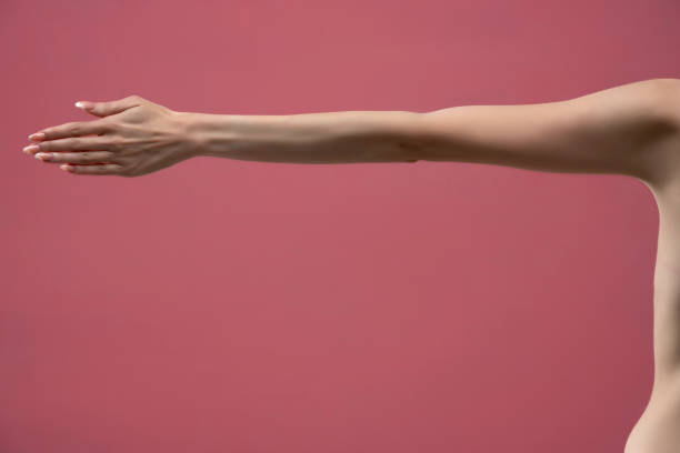 Young woman's stretched arm and palm. Isolated on pink background.