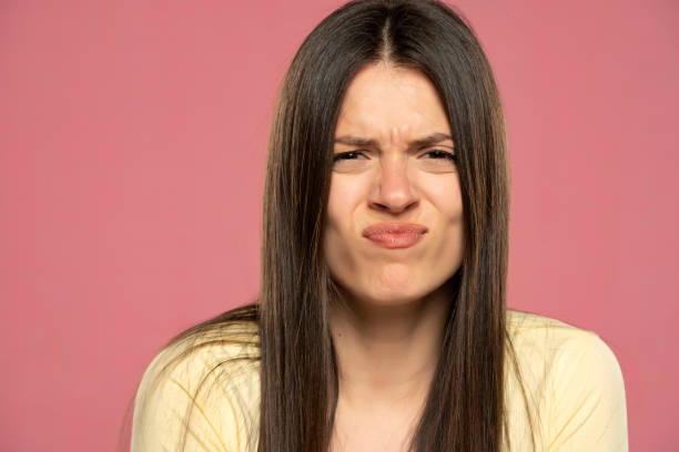 istock Uncertain young brunette woman with sour face 1580773520