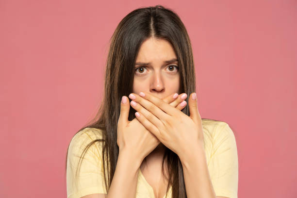 istock Ashamed woman with hand over mouth 1580774056