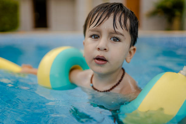 istock Happy  toddler boy having fun at pool 1580780695