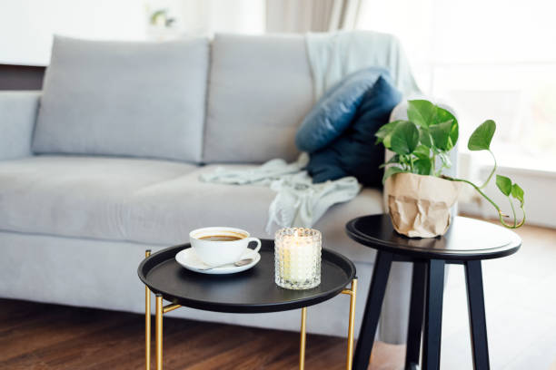 istock Large white cup of coffee and lit scented candle on round black coffee table 1580781652