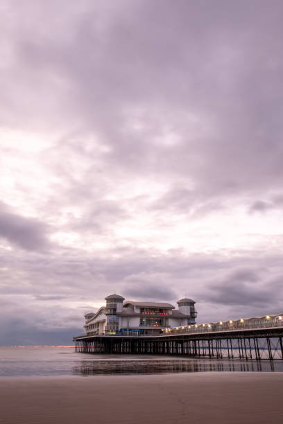 istock Long Exposure Image Of Weston-super-Mare Pier With Reflected Lights On The Wet Sand 1580782972