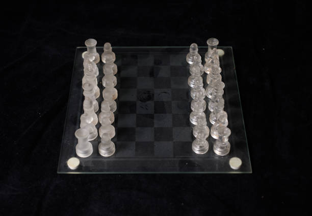 Vintage chessboard and chess piece made with glass isolated on black background