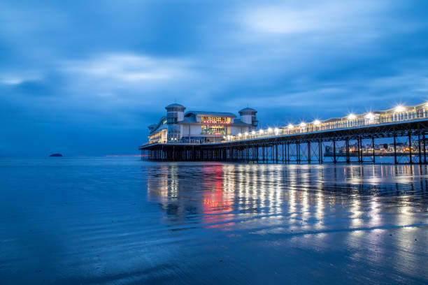 istock Long Exposure Image Of Weston-super-Mare Pier With Reflected Lights On The Wet Sand 1580783337