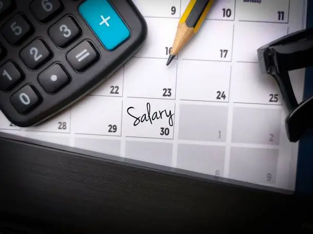 An image of a calendar with a calculator, pencil and pencil holder on top of it