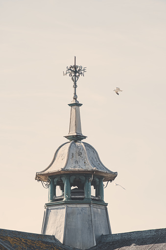 Seagulls circling around a weather vane on a turret at Weston-super-Mare.
