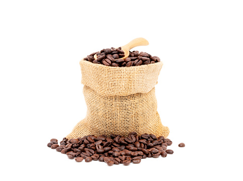 Heap of brown roasted coffee beans in burlap bags isolated on white background. fresh coffee beans concept