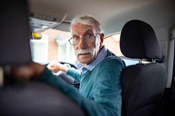 anglais conduisant une voiture et regardant en arrière pour faire marche arrière - car driving men reversing photos et images de collection