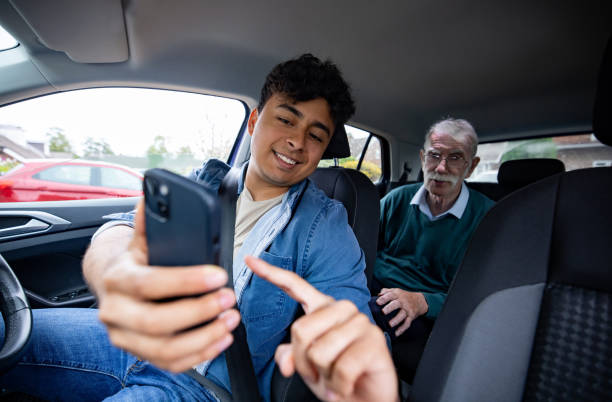 taksówkarz pokazujący trasę swojemu starszemu pasażerowi - car pooling zdjęcia i obrazy z banku zdjęć