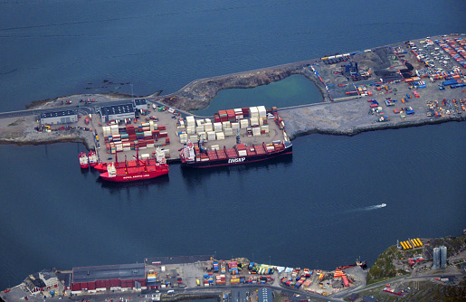 Nuuk / Godthåb, Sermersooq municipality, Greenland: Nuuk harbor container terminal, Fyrø island from the air - Nuuk Harbor is the largest port in Greenland. Container ships from the Royal Arctic Line (Government of Greenland) and Eimskip can be seen docked, both locally headquartered shipping companies keeping a lifeline on Greenland - Nuuk bay.