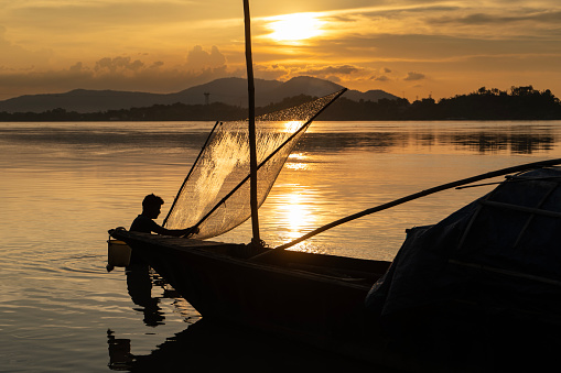 Guwahati, India. 30 July 2023. A fisherman fishing in the Brahmaputra river during sunset in Guwahati, Assam.