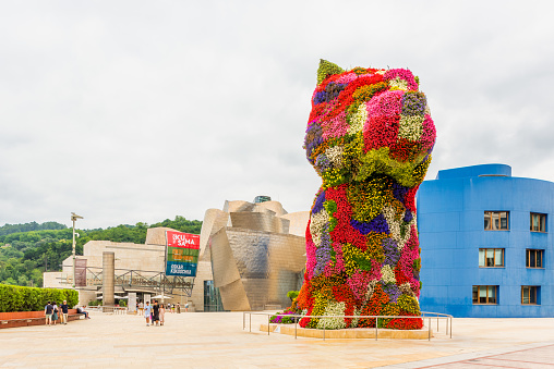Bilbao, Spain - July 3, 2023: Puppy Floral Sculpture by Jeff Koons near the entrance of the Guggenheim Museum. It stands 12 meter tall and was made in 1992.