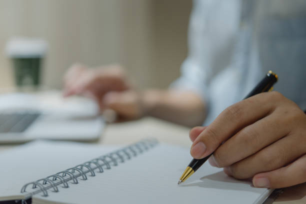 istock man hands with pen writing on notebook in the office.learning, education and work.writes goals, plans, make to do and wish list on desk. 1580881143