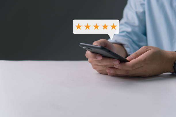 istock Customer review satisfaction feedback survey concept, man hand pressing on smartphone screen with gold five star evaluate quality of service ranking of business. 1580881693