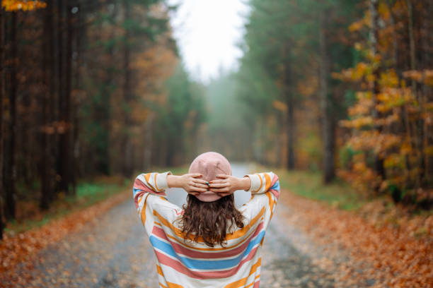 Woman walking in the autumn forest after the rain Cheerful woman walking in the autumn forest after the rain falling behind stock pictures, royalty-free photos & images