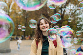 Woman standing among soap bubbles in the park