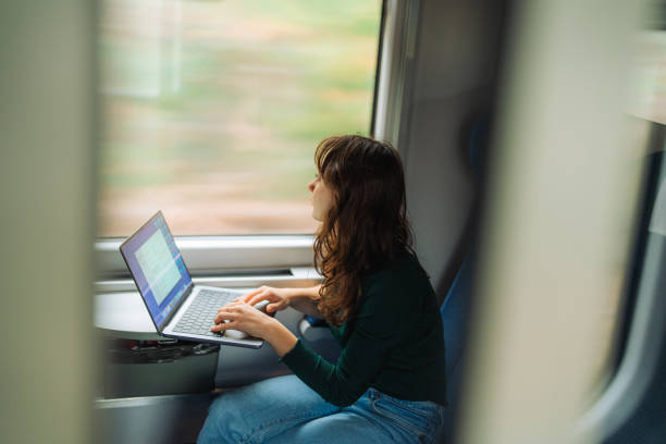 istock Woman working with laptop while traveling by train 1580899632