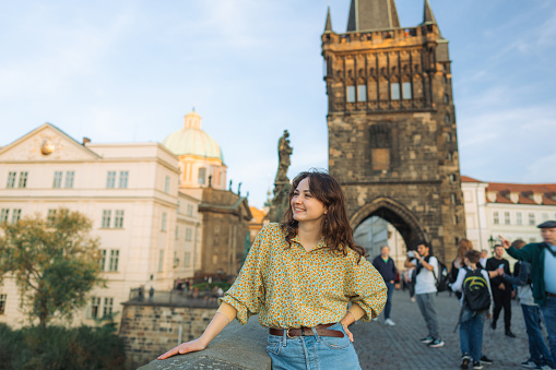 Cheerful woman walking on Karl bridge in Prague