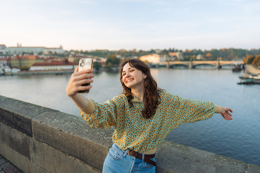 Cheerful woman making selfie on the Karl bridge in Prague