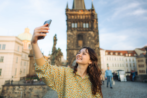 Cheerful woman making selfie on the Karl bridge in Prague