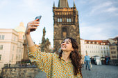 Woman making selfie on the Karl bridge in Prague