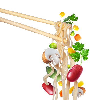 Instant noodles on wooden chopstick with vegetables and champignons close up isolated on white background