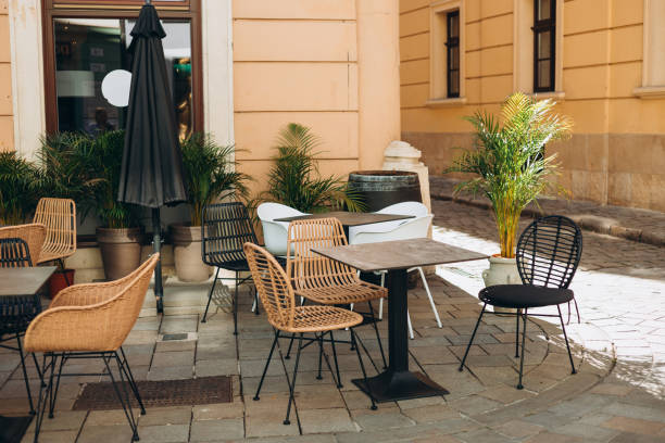 istock Empty restaurant summer terrace with tables and chairs. Reastaurant tables waiting for customers at an outdoor terrace, hipster style 1580945673