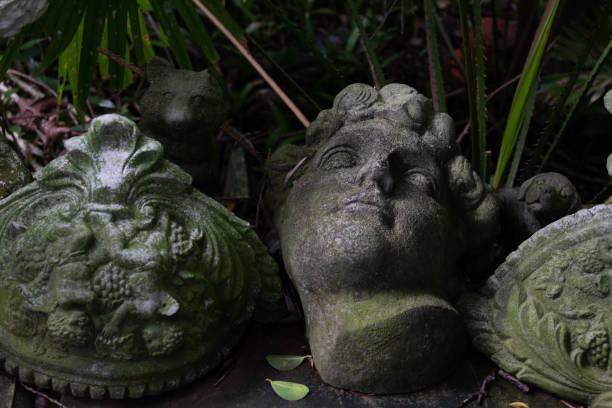 Rustic Stucco sculptures  covered with green moss , placed in the corner of the garden