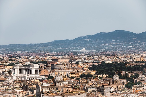 An awe-inspiring panoramic view of Rome as seen from the roof of St. Peter’s Basilica. The sprawling city unfolds beneath, showcasing its historic architecture and vibrant urban life, all framed by the iconic structures and landmarks of the Eternal City.