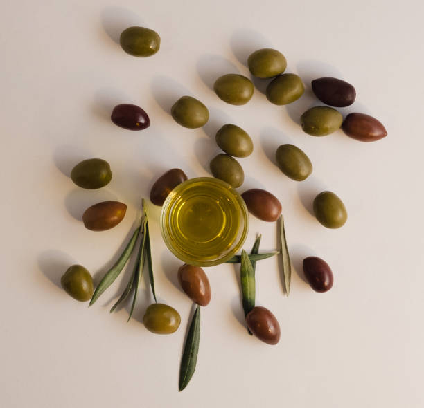 istock Simple natural composition on white background including olives , extra virgin olive oil and olive tree leaves. 1581011973