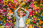 Beautiful woman smiling in front of flower wall