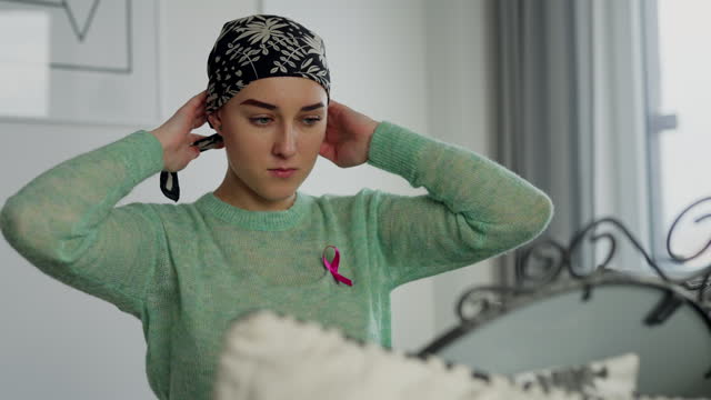 Beauty routine of young woman with cancer, getting scarf.