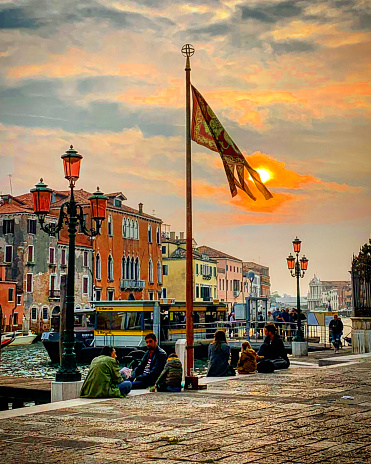 Beautiful Canal of Venice, Italy - People enjoying the sunset by the canal