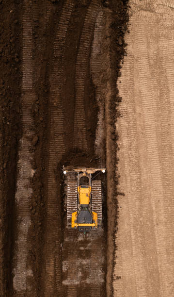 建設業界のブラウンフィールドサイトで土壌を押すアースムーバーの真上の空中写真 - earth mover working field dirt ストックフォトと画像