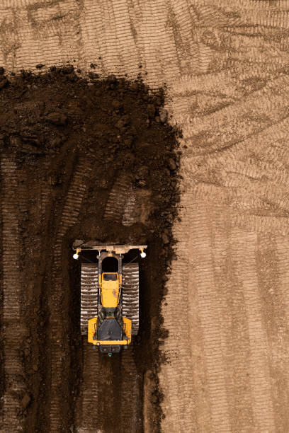 建設業界のブラウンフィールドサイトで土壌を押すアースムーバーの真上の空中写真 - earth mover working field dirt ストックフォトと画像