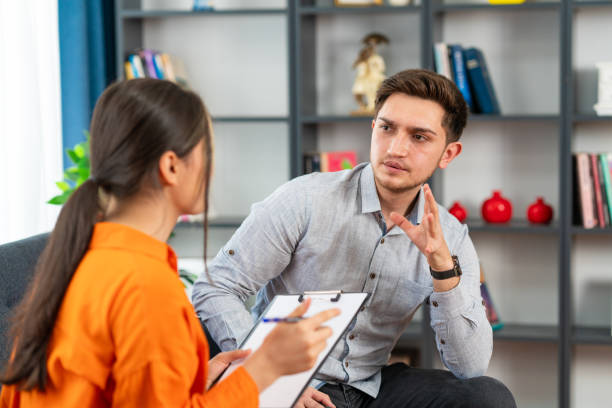 istock Handsome young man looking thoughtful while sitting in session with his female therapist 1581124005
