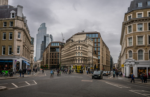 London, UK: The junction of Cannon Street and Queen Victoria Street at Mansion House station in the City of London. Looking towards the city skyscrapers.