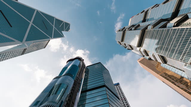 Time lapse of skyscraper, cloud on sunny sky, corporate business building in Hong Kong central financial district. Low angle view. Enterprise organisation, Asia economy, office people job work concept