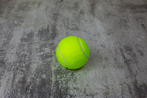 Tennis ball on concrete surface side view