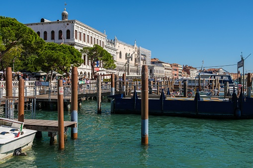 Venice, Italy – September 19, 2022: An array of boats is docked on the edge of a bustling town square, providing a picturesque view of the local area