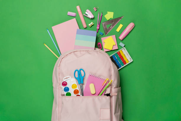 istock Pink school backpack with stationery on color background, top view 1581239671