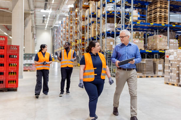 istock Senior manager discussing delivery plan with woman worker in warehouse 1581299868