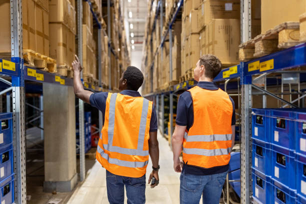 istock Rear view of two workers checking inventory while walking in the warehouse 1581299896