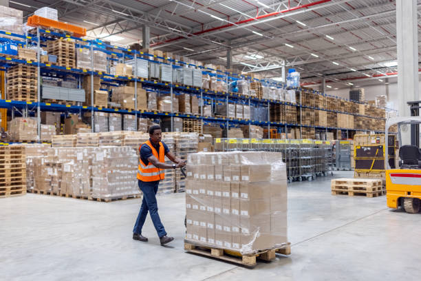 istock African man pushing a pallet jack loaded with boxes in a big warehouse 1581299916