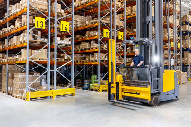 istock Worker in storehouse driving on the forklift vehicle. 1581299963