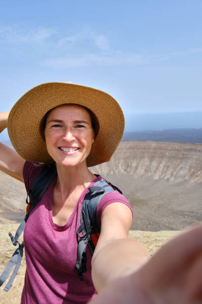 istock Smiling woman taking selfie in mountainous valley 1581302023