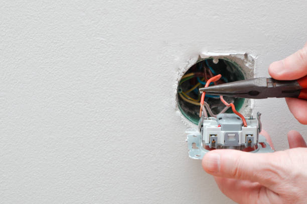 istock An electrician is replacing a wall switch. A DIY project concept. High voltage danger. Male electrician repairing wall light switch panel. 1581312191