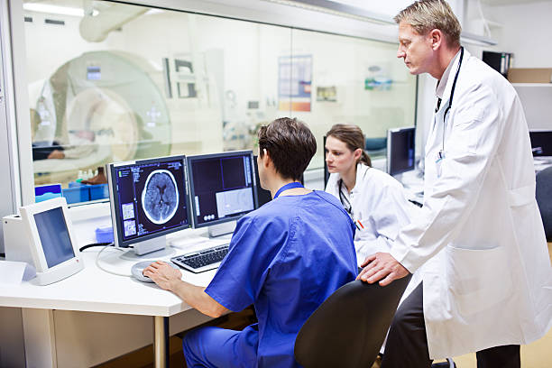 médecins ordinateur dans un examen tomography - mri scanner mri scan healthcare and medicine technology photos et images de collection