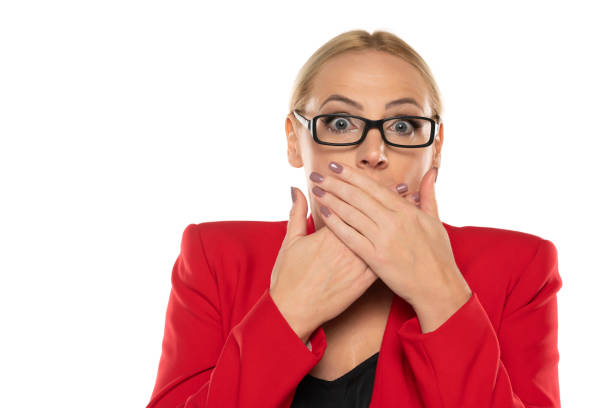 un negocio de mediana edad sorprendió a una mujer con chaqueta roja y gafas sobre fondo blanco. - women middle aging process covering fotografías e imágenes de stock